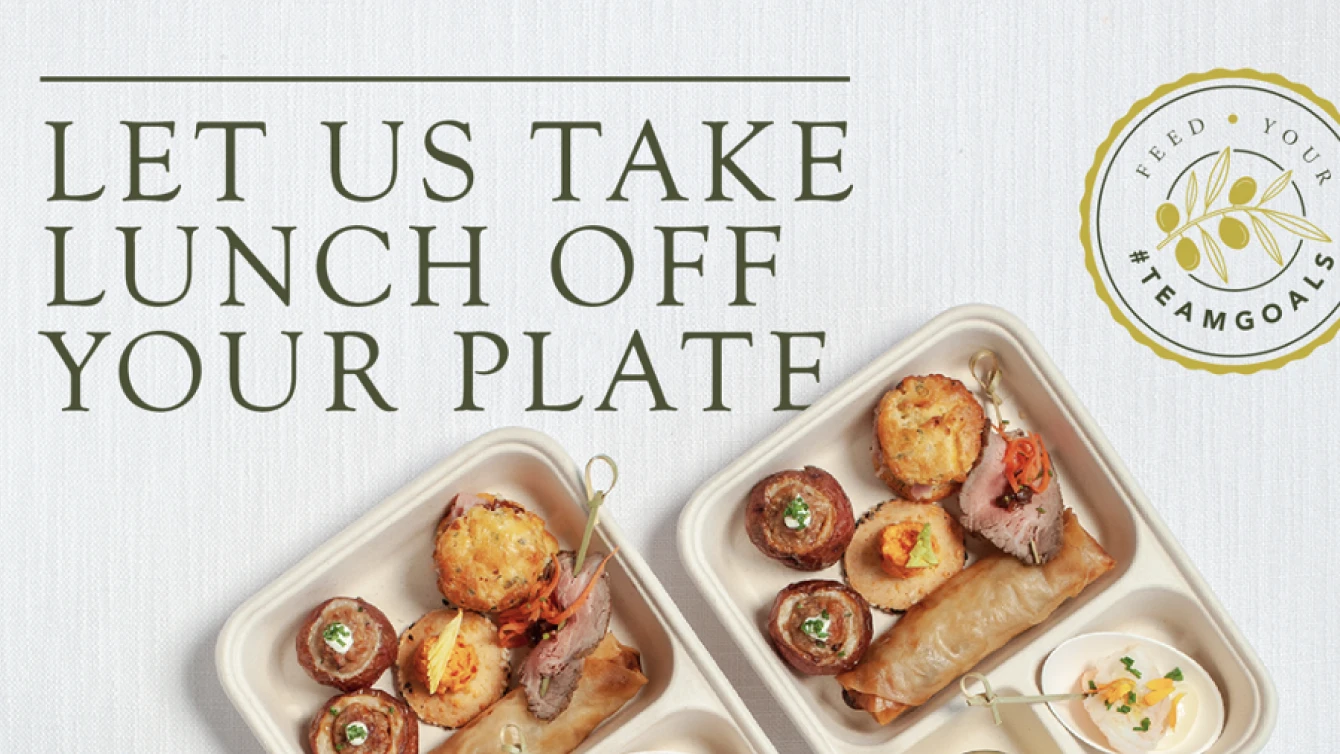 Promotional image for a catering service with the text "Let us take lunch off your plate" in large, elegant font. Below the text, there are two trays filled with assorted gourmet appetizers.