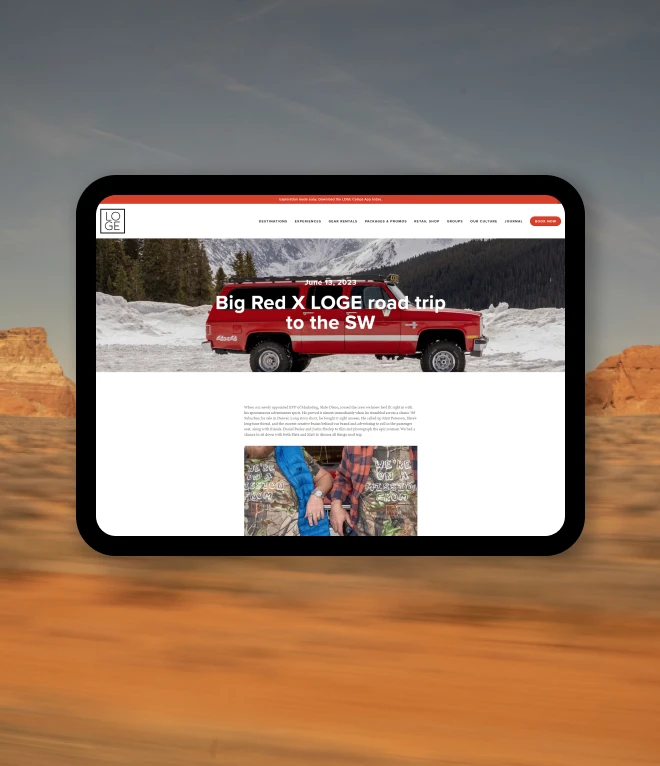 A tablet displays a website article titled "Big Red X LOGE road trip to the SW," featuring an image of a classic red truck parked in a snowy mountain setting. Below the main image, there is another image showing two people showing off their t-shirts, evoking a sense of adventure and camaraderie.