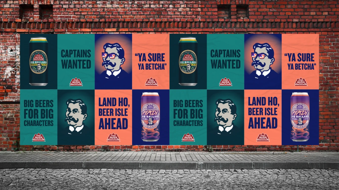 Several colorful posters are displayed on a red brick wall promoting Red Hook's Big Ballard and Hazy Big Ballard Imperial IPAs. The posters feature images of the beer cans, character illustration, and slogans.