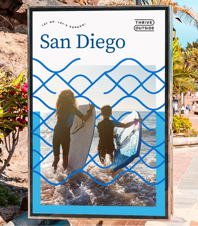 An outdoor advertisement showcases the "Thrive Outside" initiative in San Diego. The poster features two children in wetsuits holding surfboards as they head into the ocean.